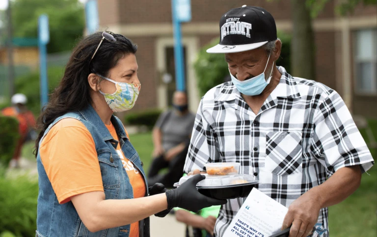 Rashida passing out packages of food during the pandemic